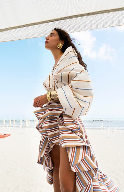 Model on beach in striped outfit